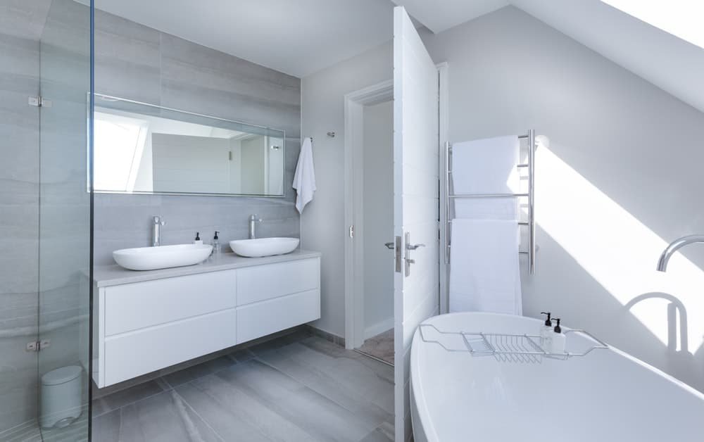 bathroom with mirror and a bath tub with a sink
