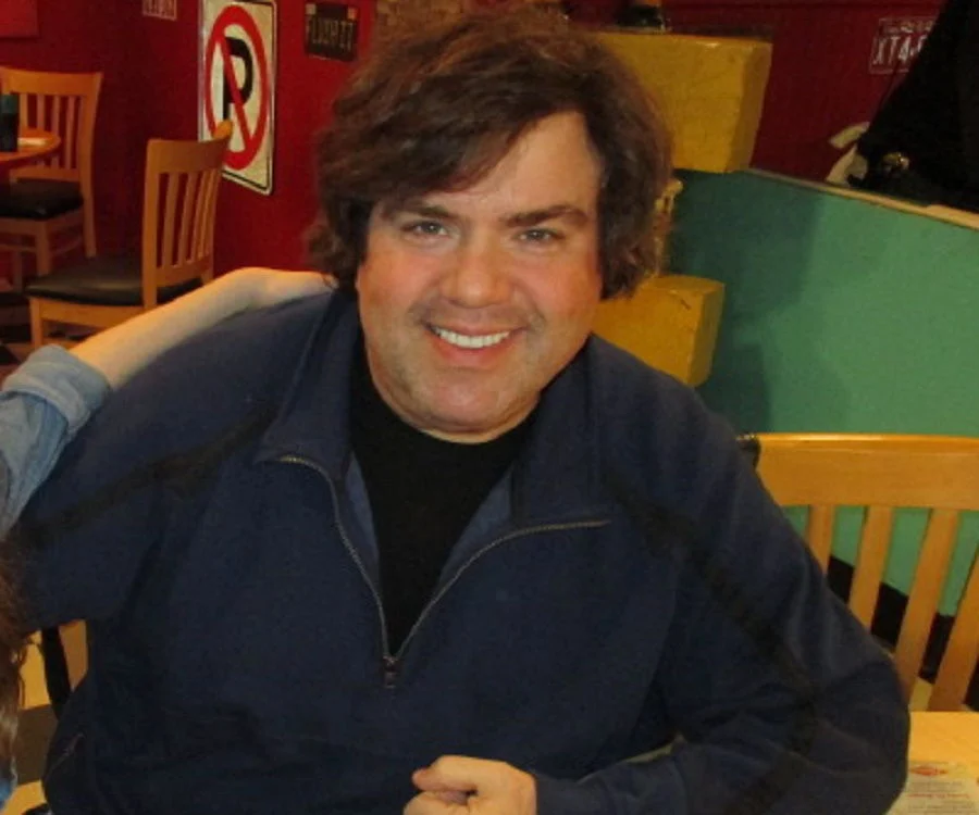 Dan Schneider sitting on a chair