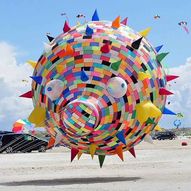 a flying big circular kite with many colors