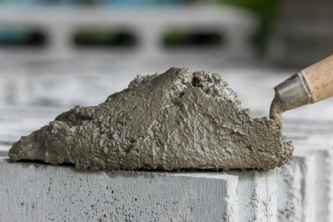 trowel full of cement mortar kept on a block